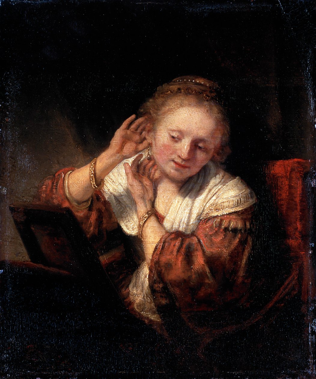 Fiatal nő, aki fülbevalót próbál fel, 1657. alkotó: Rembrandt van Rijn