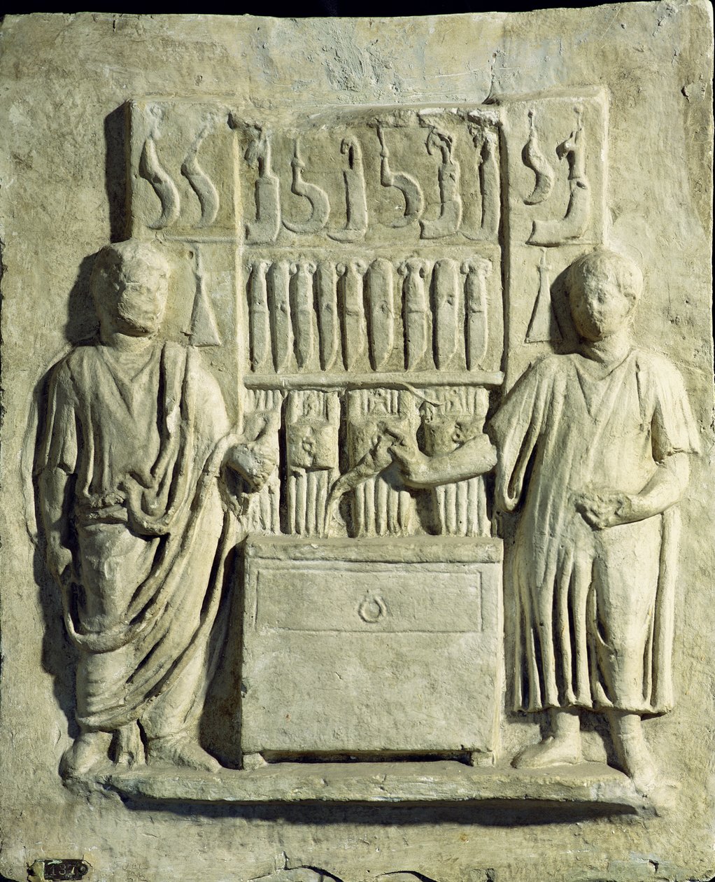 Evőeszközboltot ábrázoló dombormű alkotó: Roman