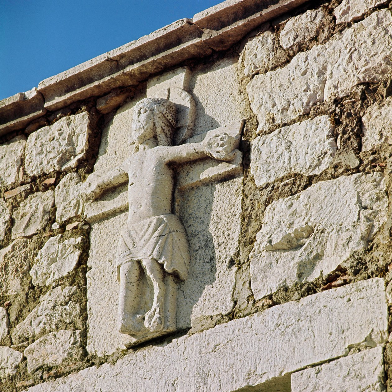 Krisztus keresztre feszíti a 13. századi kőszobrot. A román stílusú San Bartolomeo templom portálja, Campobasso Olaszország alkotó: Romanesque