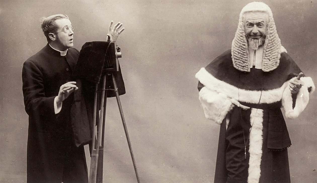 Egy revénás férfi a fényképezőgépe lencséjét egy pápának öltözött férfira irányítja alkotó: Rotary Photographic Co Ltd