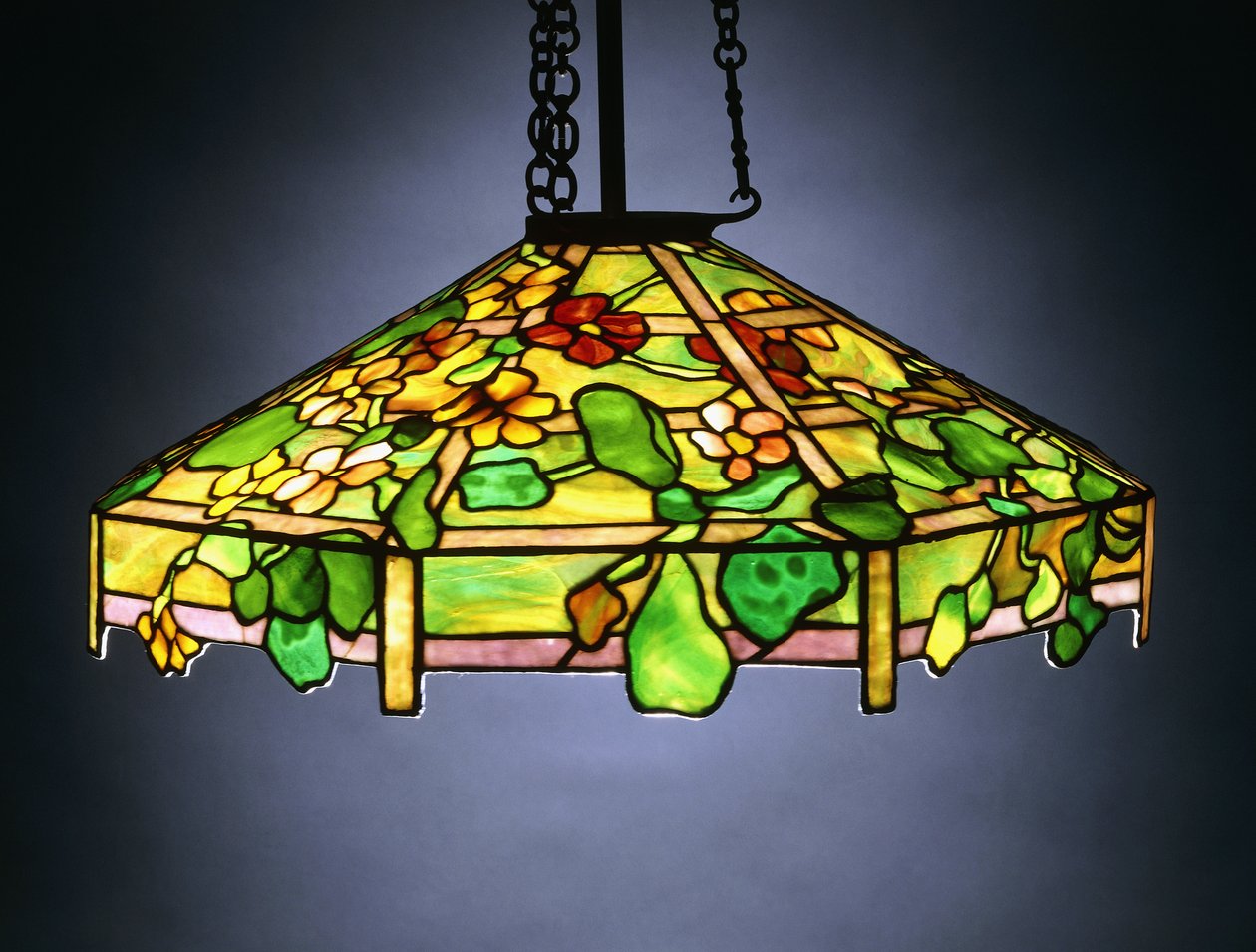 Egy „Nasturtium” ólmozott üvegből és bronzból függő csillár alkotó: School American