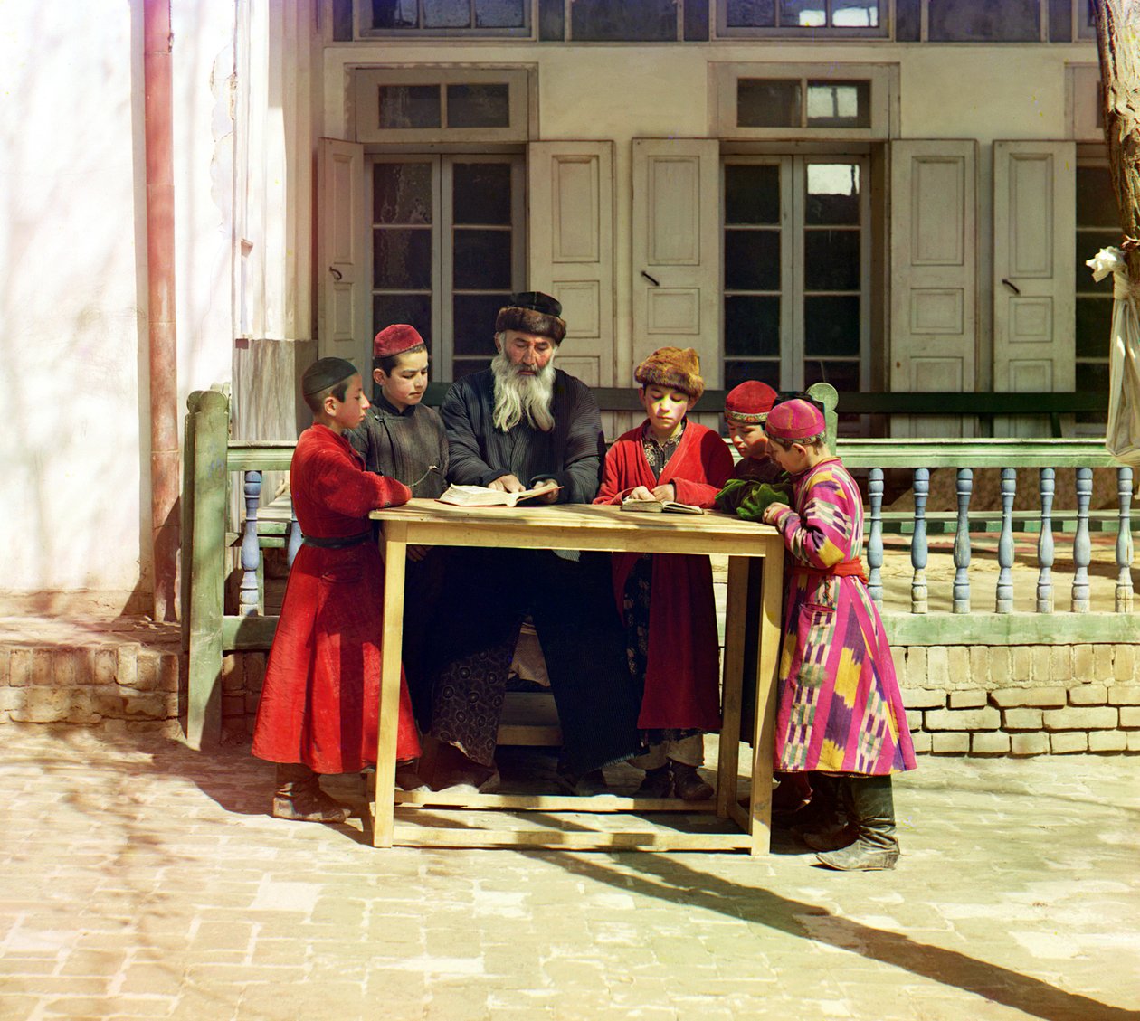 Zsidó gyerekek csoportja tanárral egy ház előtti asztalon, Szamarkand, Orosz Birodalom, 1905 és 1915 között alkotó: Sergey Prokudin Gorsky
