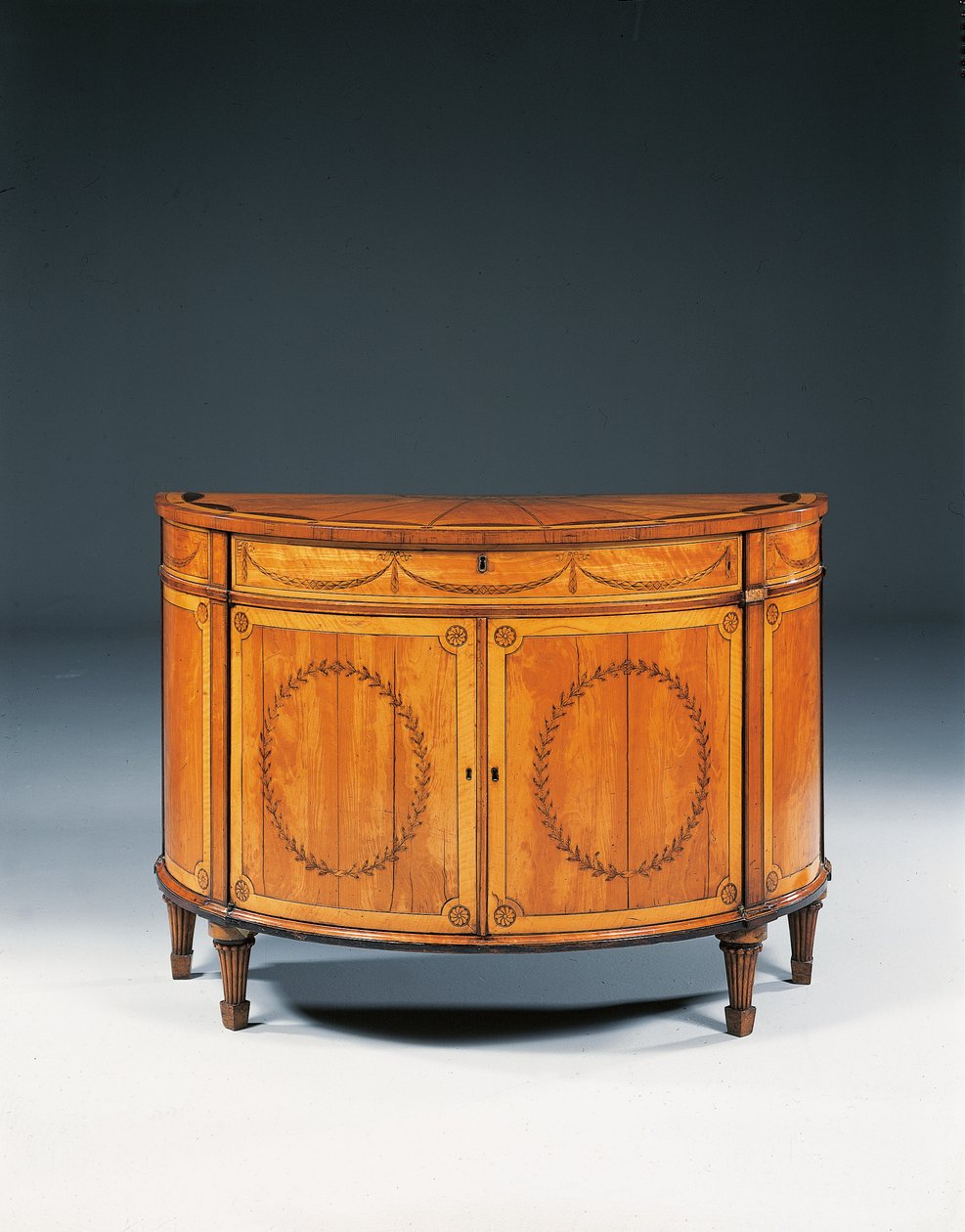 III. György intarziás félholdas komód, 1760-79 körül (szaténfa, amaránt és tulipánfa) alkotó: Thomas (attr.to) Chippendale
