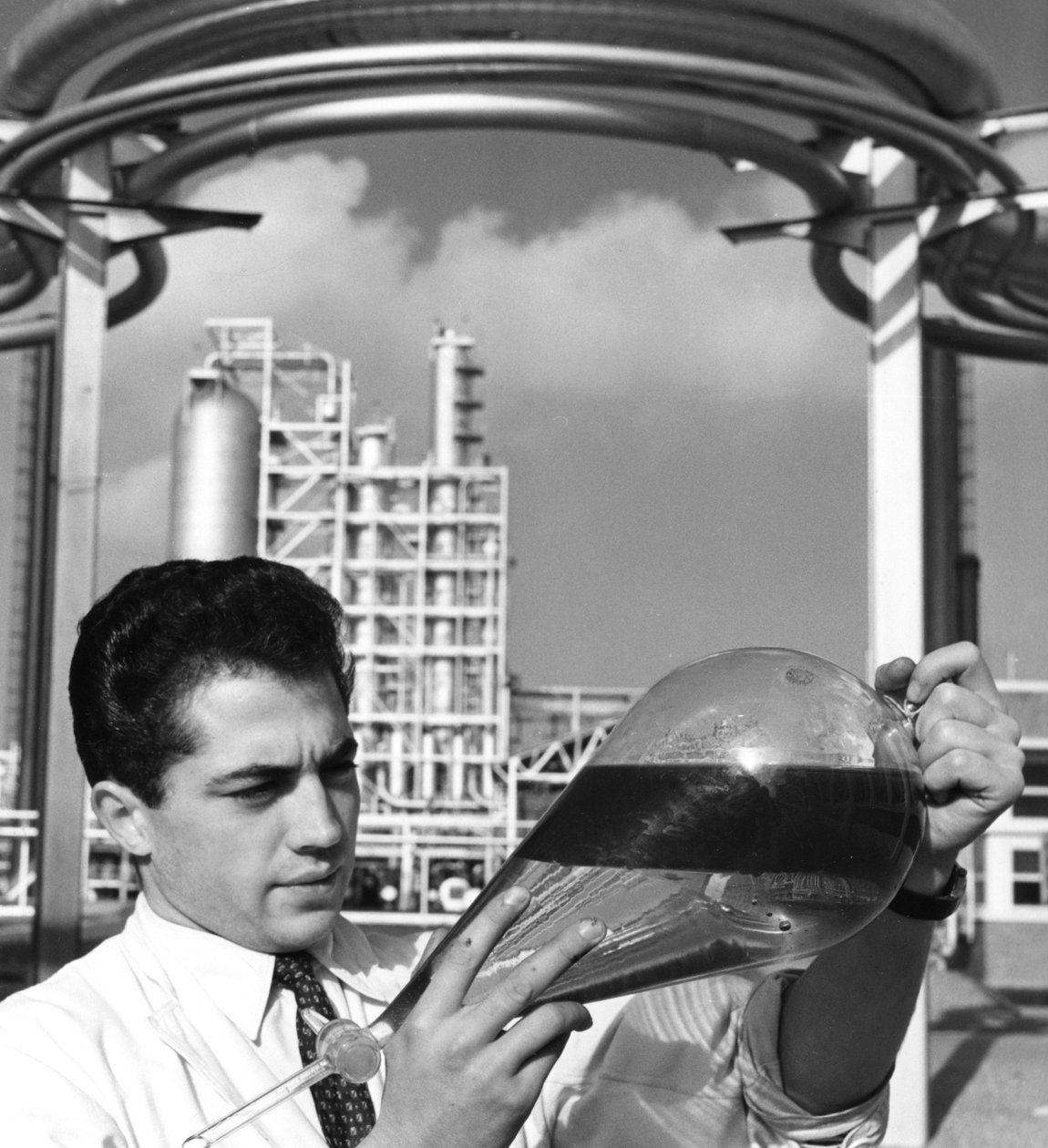 Egy laboratóriumi dolgozó olajválasztótölcsért tart, Dunkerque-i finomító, Franciaország, 1950-es évek alkotó: Unbekannt