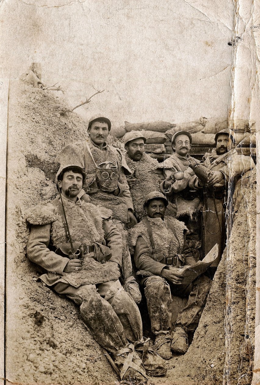 Első világháború (1914-1918): Szőrös katonák téli ruhában egy lövészárokban 1916-1917-ben. Báránybőr kabátot és gázálarcot viselnek. alkotó: Unbekannt