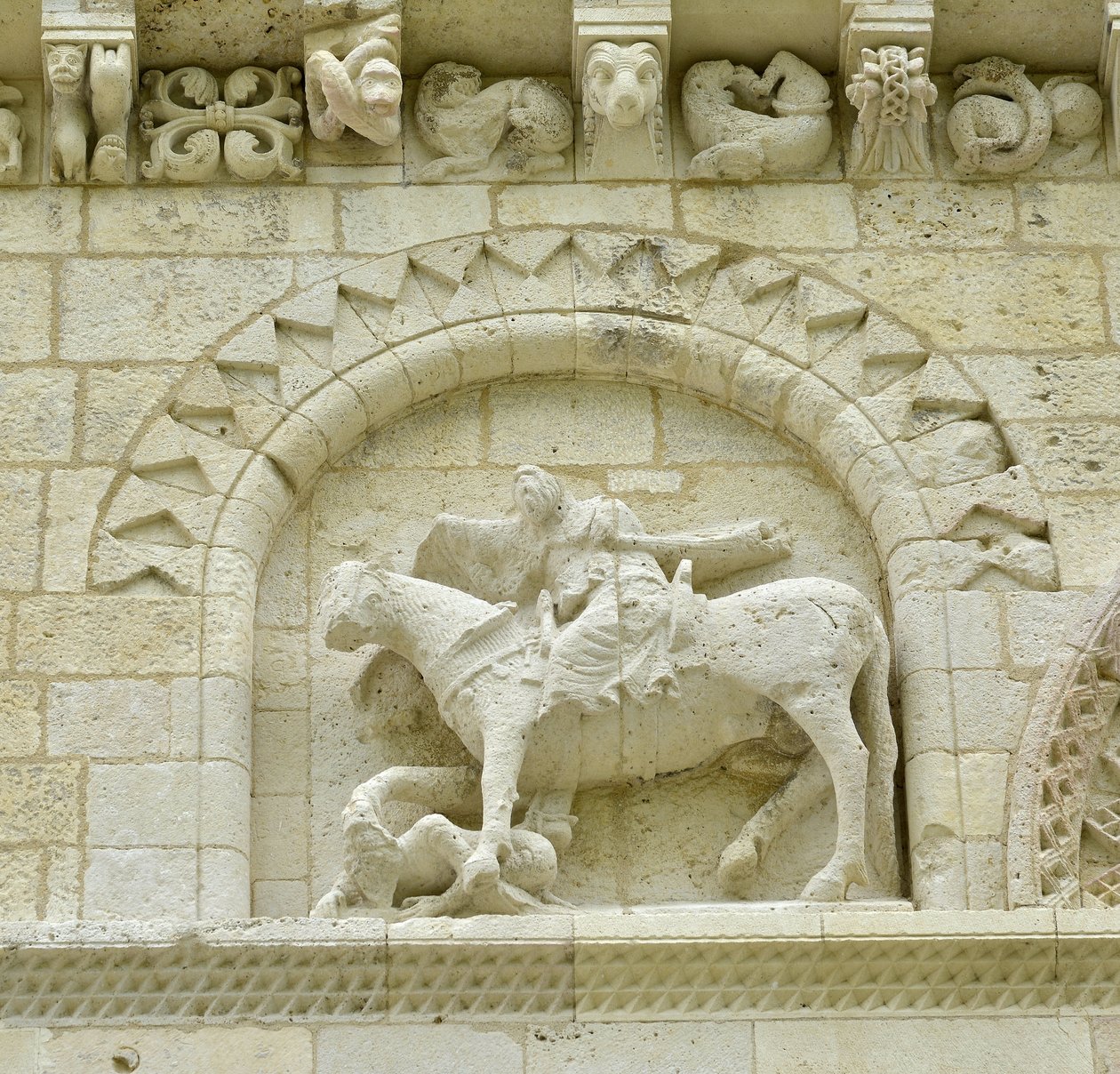 Román művészet: a homlokzat részlete, amely Hugues de Surgeres-t és Geoffroy de Vendome-ot vagy I. Nagy Konstantin császárt ábrázolja, akinek a ló lába Eretnekséget és a gonosz és a halál diadalmaskodó Krisztusát tapossa, Notre Dame (Notre-Dame) de Surgere alkotó: Unbekannt