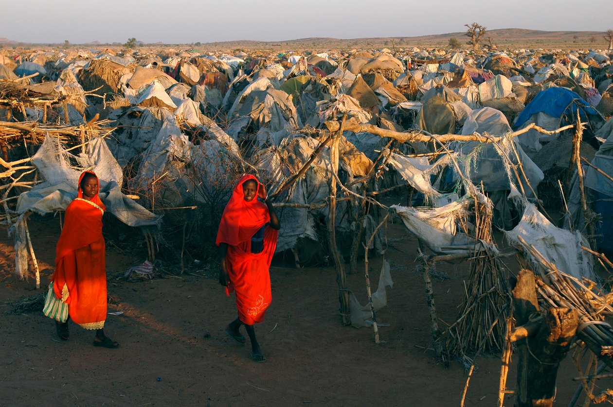 Élénkvörös ruhába öltözött nők sétálnak át a belső menekültek Otash-i táborán alkotó: Unbekannt Unbekannt