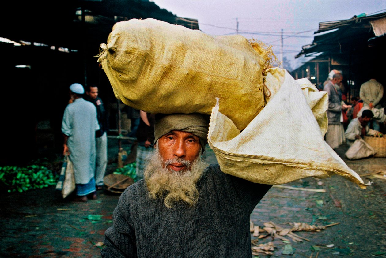 Egy zöldség eladó portréja. Abdus Samad zöldséget vásárol a lyukas piacon, és eladja az utcán. Nirala kacha bazár, Khulna, Banglades. alkotó: Unbekannt Unbekannt