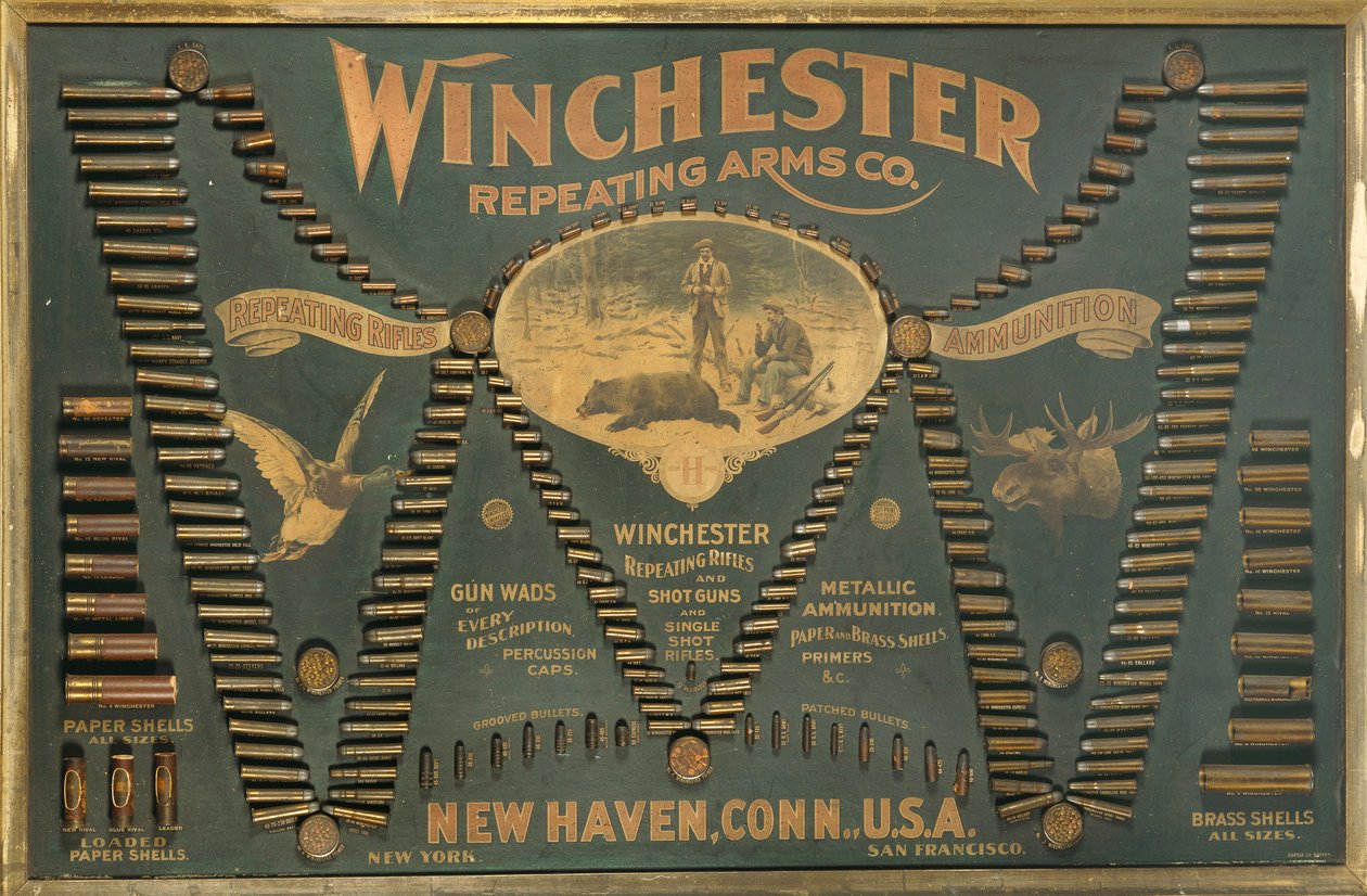 Winchester Cartridge kijelzőtábla fém, sárgaréz és papírtokos puskák és sörétes töltények átfogó választékával, kiterjesztett "W" formájú elrendezésben. alkotó: Unbekannt