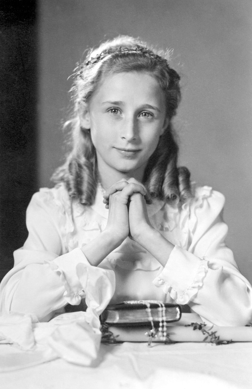Keresztény lány imahelyzetben összefogott kezekkel, bibliával, rózsafüzérrel és gyertyával (az áldozás fényképe). Fényképezés 1932 körül alkotó: Unbekannt