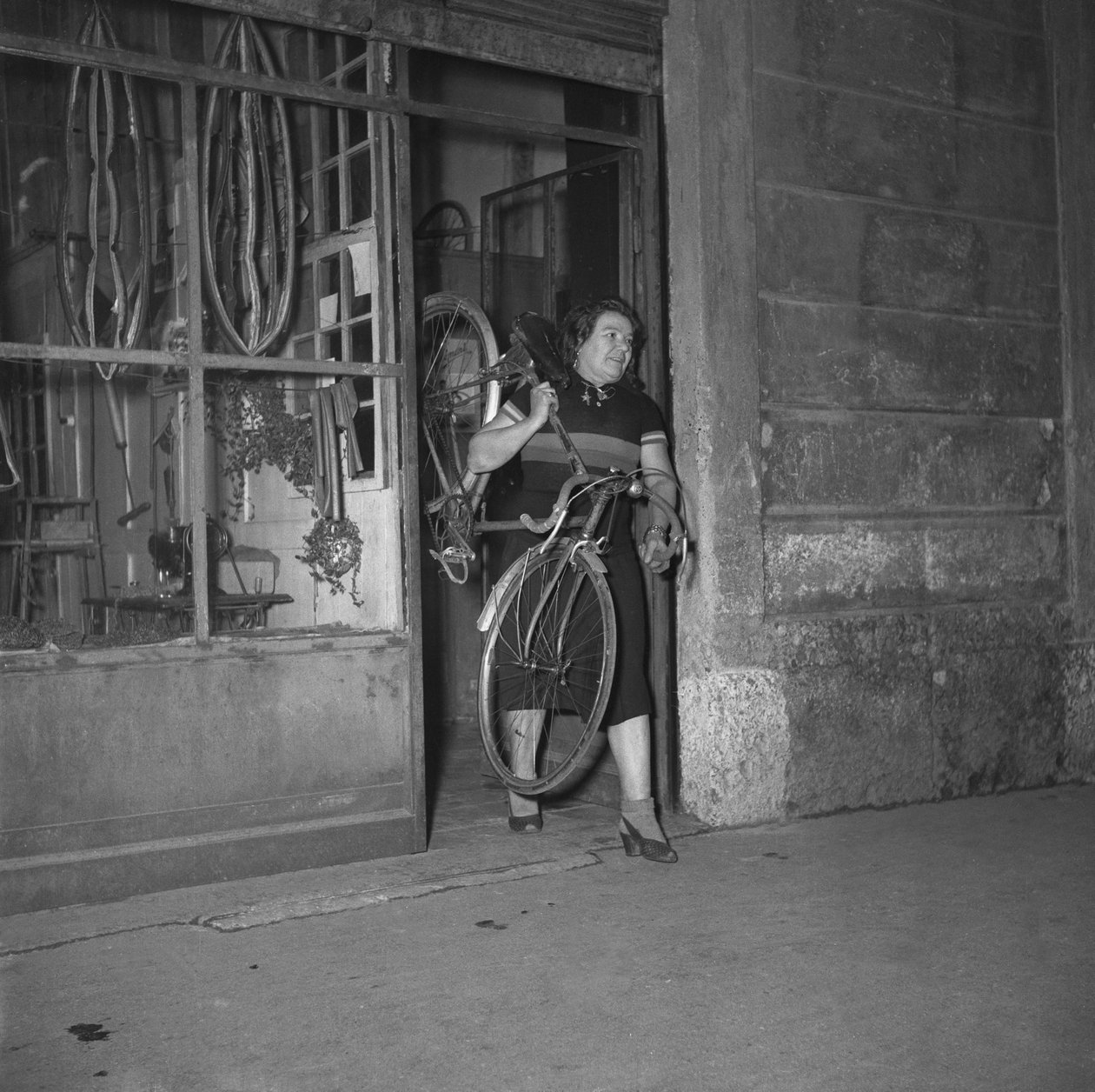 Alfonsina Strada (Alfonsa Rosa Maria Morini) kerékpáros kiszáll a Varesina utca 80. szám alatti üzletéből, Milánó, Olaszország alkotó: Unbekannter Künstler