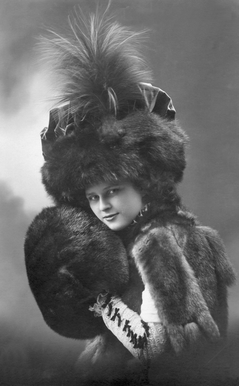 Divat: fiatal nő szőrmében (kabát, tollas kalap és ujj). Annees 1920-1930 Történelmi divatfotó, női modell. alkotó: Unbekannter Künstler