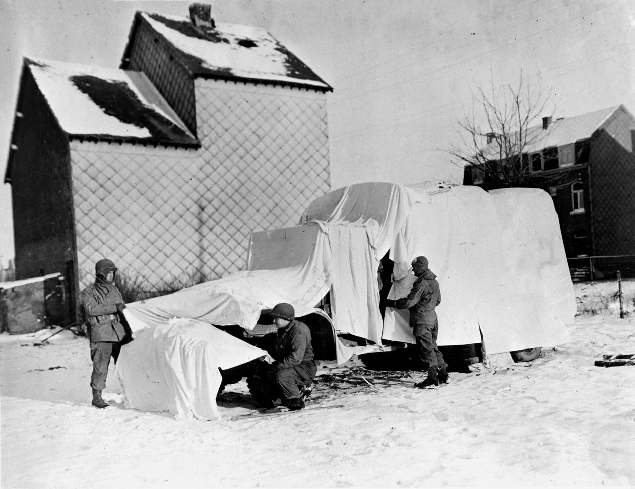 Második világháború (1939-1945) – II. világháború (II. vagy 2. világháború): Bastogne (Belgium) közelében 1944. december végén: Ezek az amerikai katonák fehér lepedővel eltakarnak egy teherautót az ellenség szeme előtt alkotó: Unbekannt