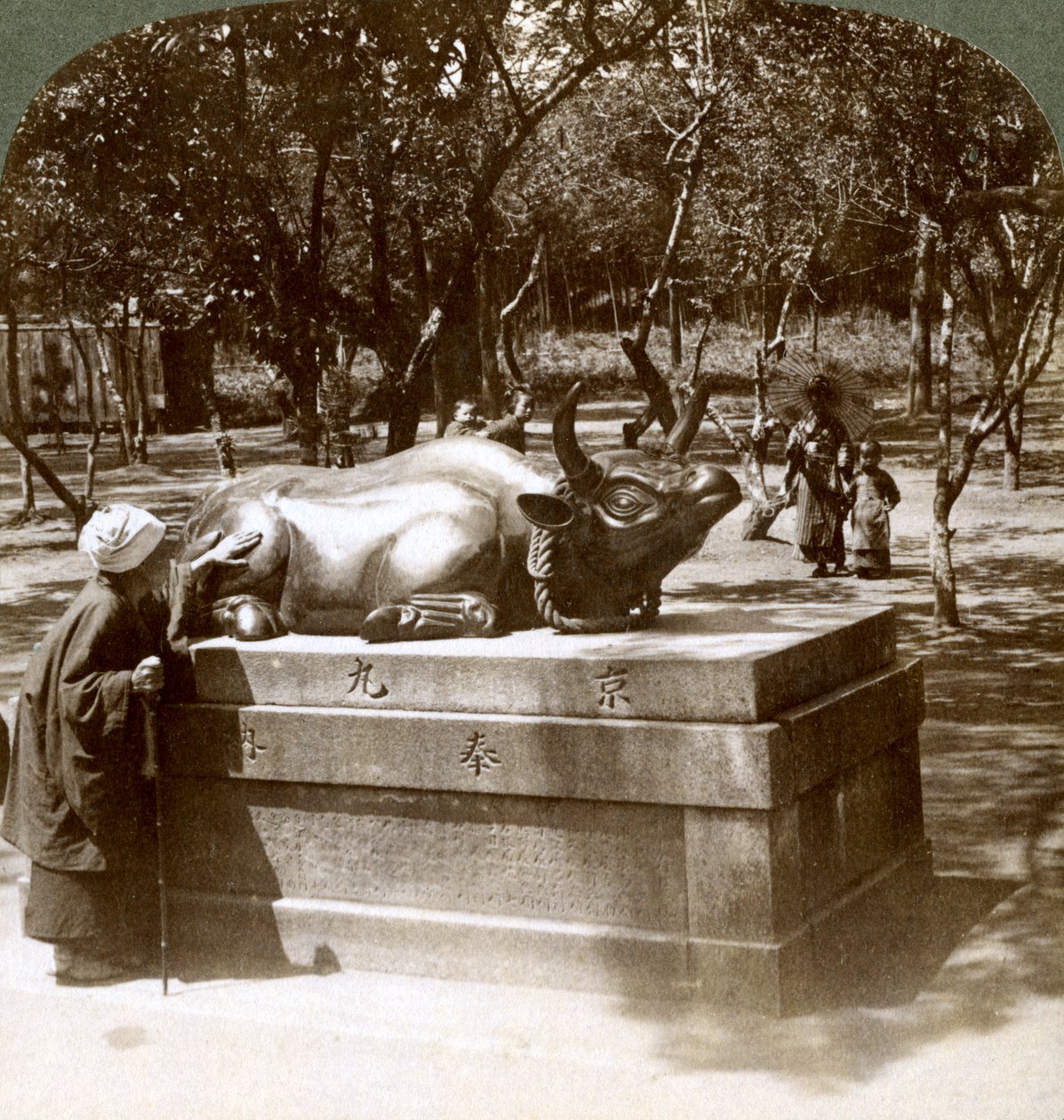 Jámbor nő, aki bronzbikát simogat, hogy gyógyítsa a reumát, Kitano Tenjin templom, Kiotó, Japán, 1904 alkotó: Underwood and Underwood