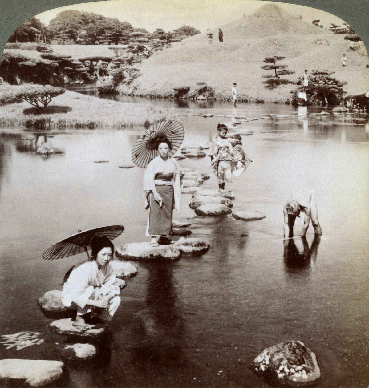 Nők átkelnek a tavon lépcsőkövön, Suizen-ji kert, Kumamoto, Japán, 1904. alkotó: Underwood and Underwood