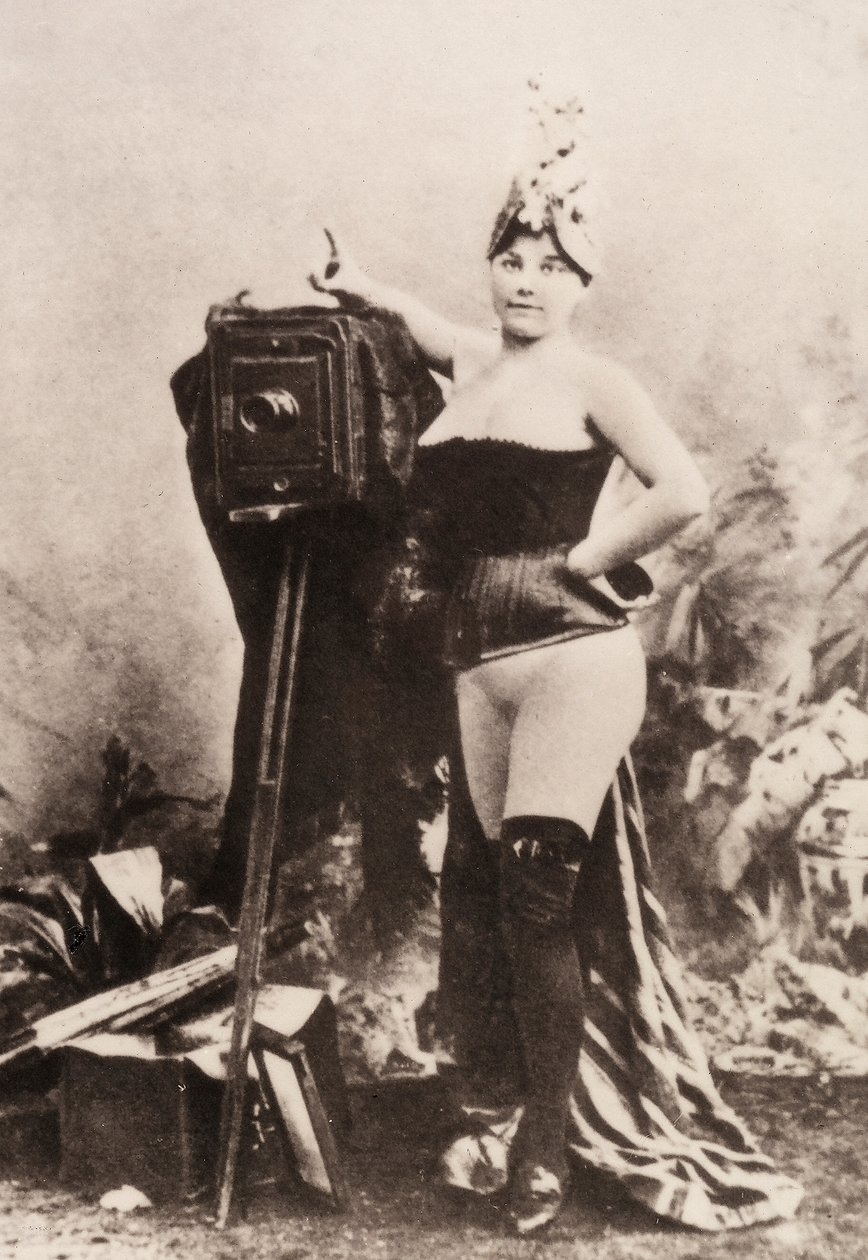 Egy antik fényképezőgépre támaszkodó, részben meztelen nő portréja. alkotó: Unknown photographer