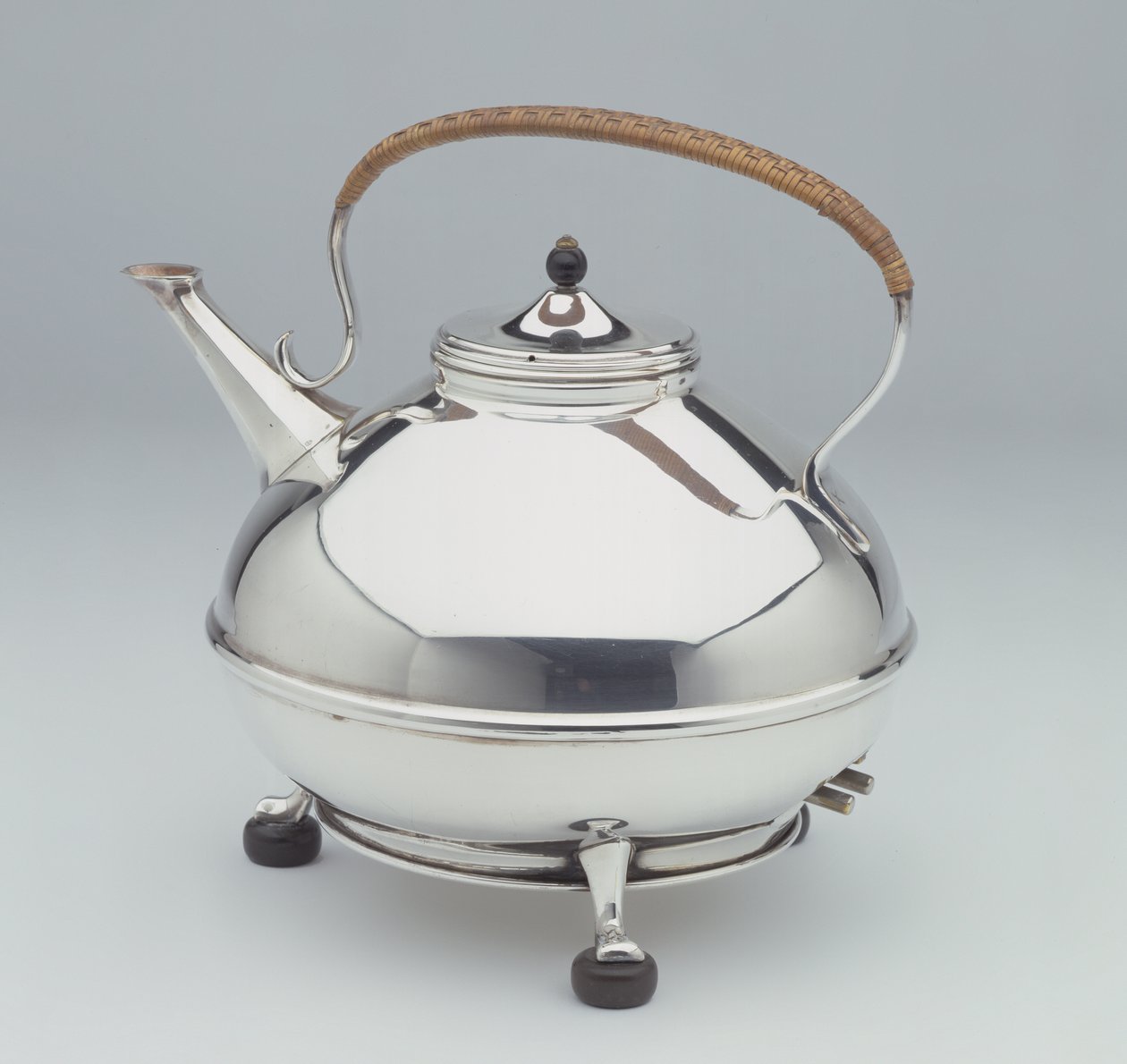 Elektromos vízforraló, 1905 körül (ezüst tányér ebonizált lábakkal, gombbal és rattan nyéllel) alkotó: William Arthur Smith Benson