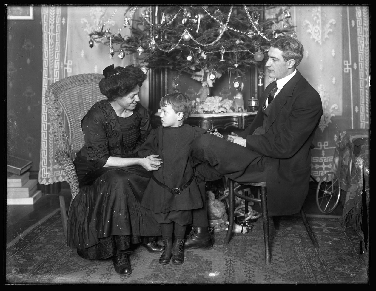 Dan Seymour és családja kötetlen pózban, karácsonyfa alatt ülve, 1912 karácsonya alkotó: William Davis Hassler