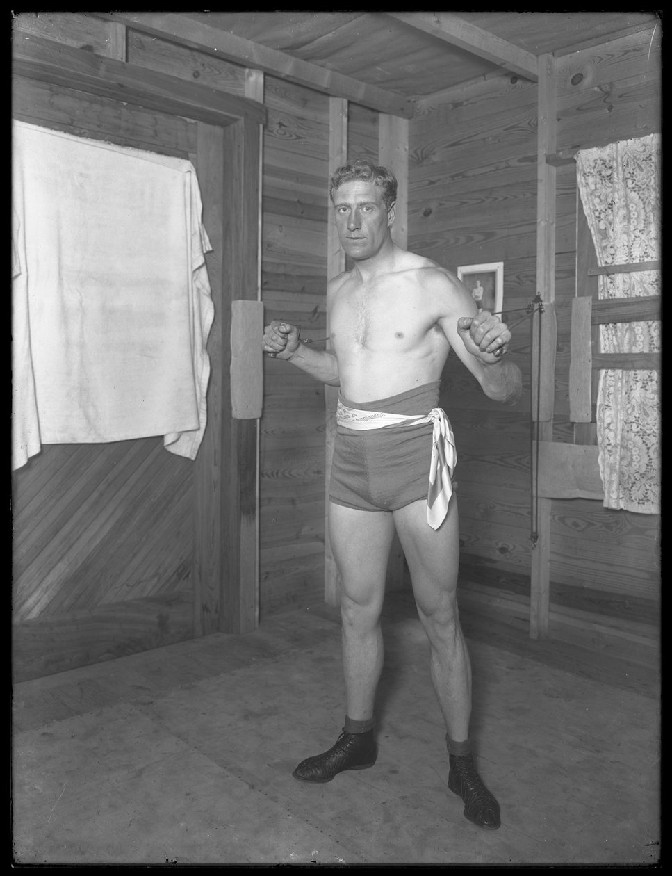 William Thomas Wells angol bokszoló (Bombardier Billy Wells), pózol edzőruhában, súlycsigákkal, 1911 körül. alkotó: William Davis Hassler