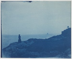 Nő, aki szkúnert néz egy sziklás hegyfokról alkotó: American Photographer