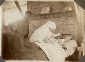 Első világháború 1914-1918: ápolónő blúzban katonát borotvál (a francia háborús sebek ágyban hevernek), Couville-ben, Manche-ban, Alsó-Normandia (Alsó-Normandia), Franciaország. Névtelen fénykép 1917. július. Magángyűjtemény, Stella. alkotó: Anonymous Anonymous