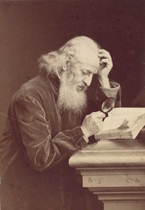 [Szakállas ember nagyítóval egy kéziratot vizsgál], 1870-es évek.