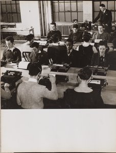 [Emberek ülnek írógépek előtt, miközben fejhallgatót viselnek]