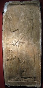 Pap kezében egy gránátalma ág. Részlet egy mészkő domborműről, II. Sargon (vagy Sharroukin, asszír király i.e. 722–705) erődjéből Dur Sharrukinban (ma Khorsabad, Irak). Asszír művészet, ókor, Kr.e. 8. század alkotó: Assyrian