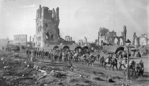 Azonosítatlan ausztrál géppuska részleg tömött lovakkal a Posztócsarnok romjai mellett. Jegyezze meg, hogy több motoros teherautó parkolt a háttérben, 1917. október 19 alkotó: Australian Photographer