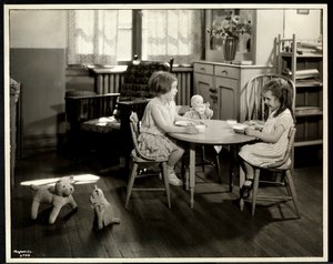 Két vak látássérült lány eszik egy kis asztalnál egy babával a New York-i Vakok Egyesületében, 111 East 59th Street, New York, 1933 (ezüst zselatinos nyomat)
