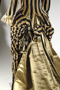 Estélyi ruha, 1884 körül (hátul ferde nézet a nyüzsgő részletekről). Selyem szatén és vágott bársony, csipke, selyemszál bojt és rojt. Charles Frederick Worth, Franciaország.