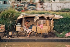 Karton kunyhó, egy szennyvízcsatorna mentén, otthonként szolgál. Jakarta, Indonézia.