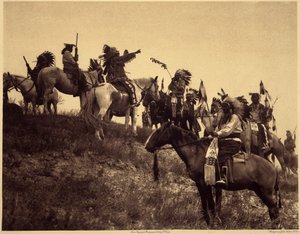 razzia tervezése. Az indiánok lenyűgöző jellegzetes jelmezeikben rendkívül festői csoportokba állnak össze. Ez egy csapat Sioux Ogalala-ból (Oglala), egy dombon, ahonnan kilátás nyílik a Wounded Knee Valley-re a Pine Ridge Reserve-ben, Dél-Dakotában. Fotó  alkotó: Edward Sheriff Curtis
