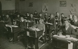 Férfi tanulók ülnek az iskolapad mögött az iskolai óra alatt alkotó: English Photographer