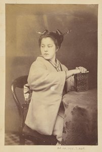 [Ülő japán nő egy cartes-de-visite albumot tart az asztalnál] alkotó: Felice Beato