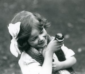 Egy fiatal lány, Betty, aki egy keleti indigókígyót tart a kezében, a londoni állatkertben, 1924 alkotó: Frederick William Bond