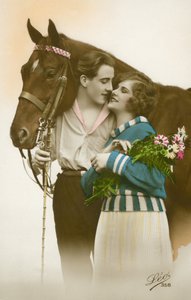 Csókolózni készülő pár barna ló mellett állva (színes fotó) alkotó: French Photographer
