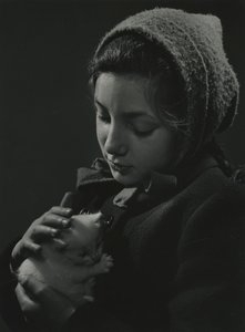 Kislány egy fehér cicát tart a karjában. 1950-es évek eleje