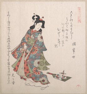 Lány és egy hagoita (japán tollaslabda-ütő és tollaslabda)