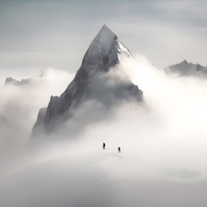 zwei menschen beim skifahren über einem wolkenverhangenen berg 3