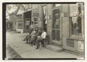 Férfiak kutyával ülnek a padon a General Store előtt alkotó: Lewis Wickes Hine