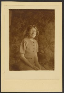[Egy nő portréja, aki egy faliszőnyeg előtt ül] alkotó: Louis Fleckenstein