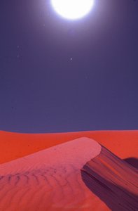 Éjfélkor a sivatagi homokdűnék fölött fáklyák izzanak a Lekhwair olaj- és földgázkitermelő közelében...