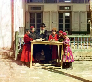 Zsidó gyerekek csoportja tanárral egy ház előtti asztalon, Szamarkand, Orosz Birodalom, 1905 és 1915 között
