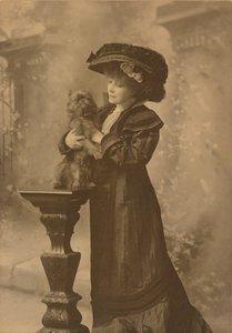 [Sarah Bernhardt egy műteremben áll, kezében egy kis fekete kutyával egy díszes, faragott fa talapzaton] alkotó: Theodore C. Marceau