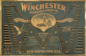 Winchester Cartridge kijelzőtábla fém, sárgaréz és papírtokos puskák és sörétes töltények átfogó választékával, kiterjesztett "W" formájú elrendezésben. alkotó: Unbekannt