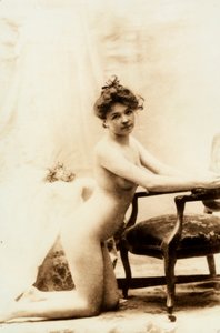 Akt portré egy fiatal nőről, aki egy kis fotel előtt térdel. alkotó: Unknown photographer