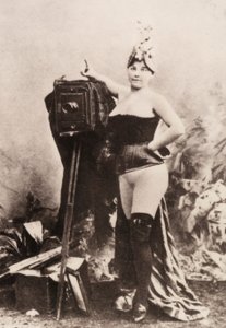 Egy antik fényképezőgépre támaszkodó, részben meztelen nő portréja. alkotó: Unknown photographer