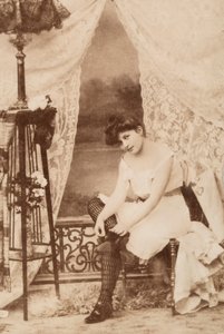 Fiatal nő portréja intim ruházatban, ülve, amint a cipőjét fűzi. alkotó: Unknown photographer