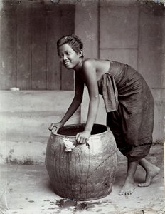 Fiatal, mosolygós thaiföldi nő, aki egy nagy konténert tologat alkotó: Unknown photographer